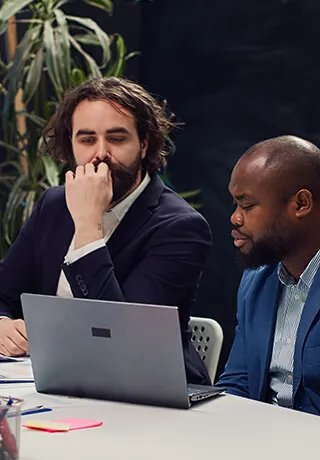 man having a conversation with his friend in the office using their laptop device